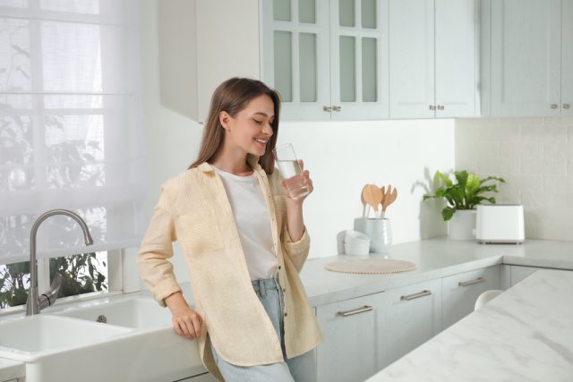 a woman holding a glass of water