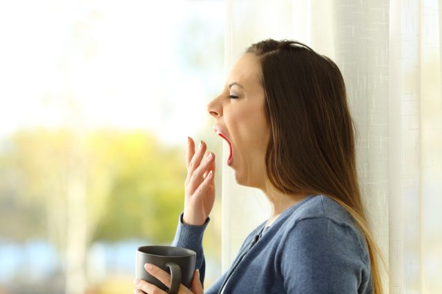 side view of a woman yawning